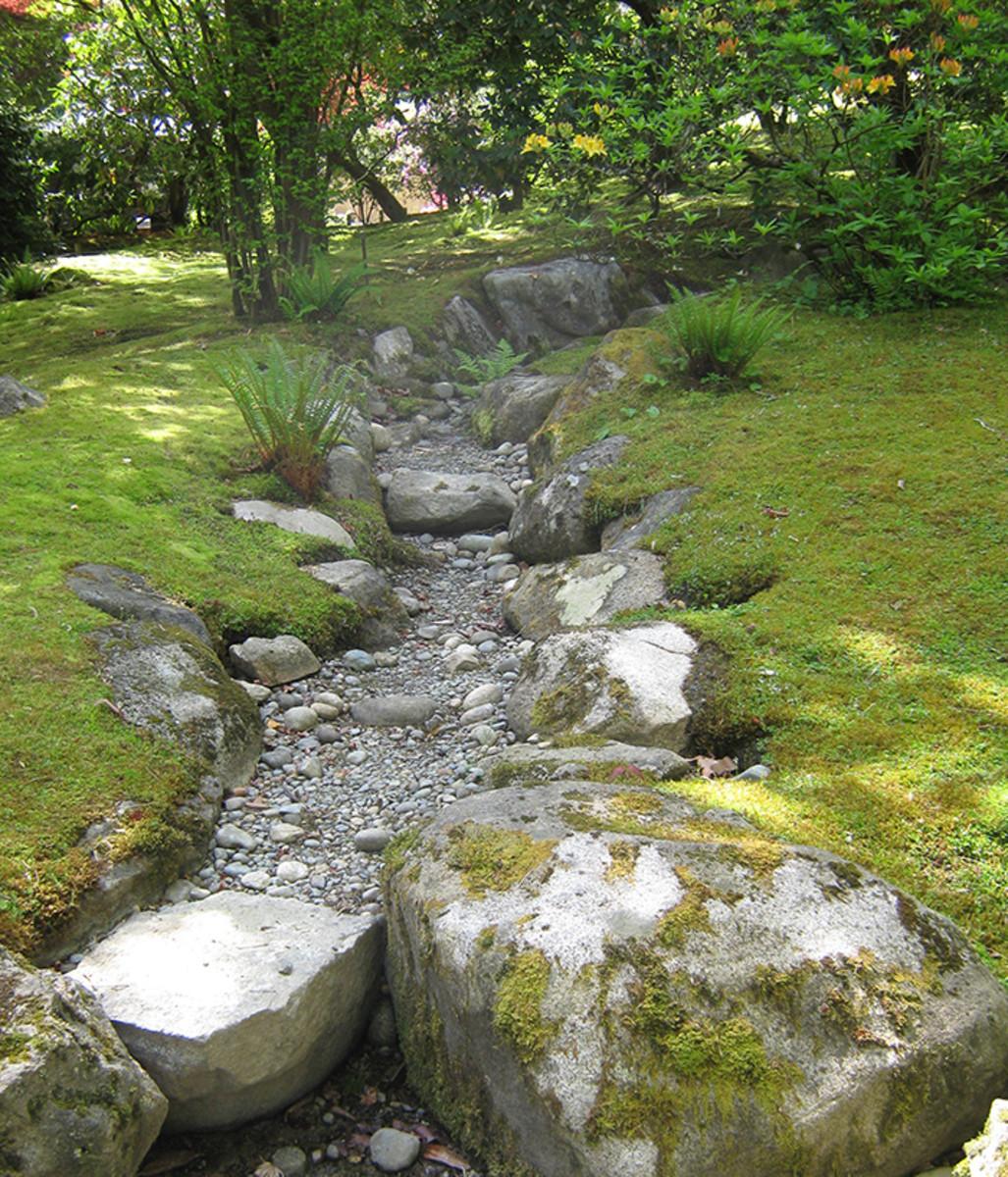 A constructed dry streambed looks natural because it uses different sizes of stones and incorporates gentle curves. In dry times it's a pretty element; in heavy rain it facilitates drainage from the site.